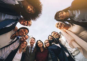 Diverse group of people in a semi-circle looking down smiling